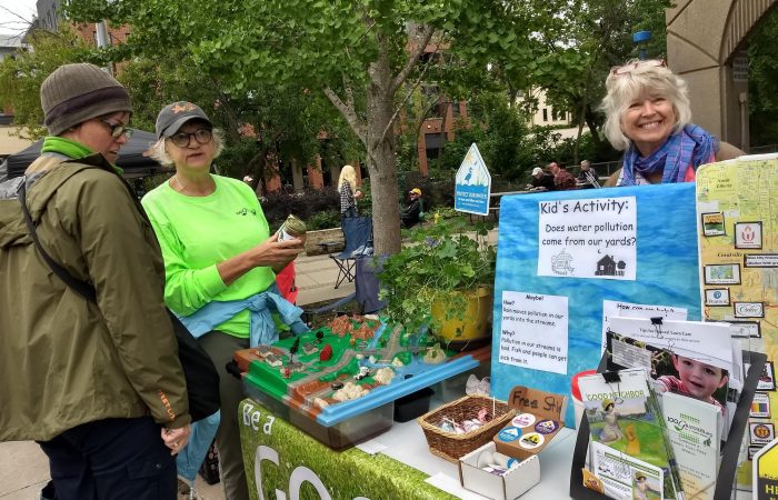three people by a table of paper resources of information